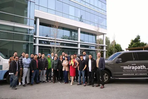 A photograph of the Mirapath staff outside of the company headquarters.